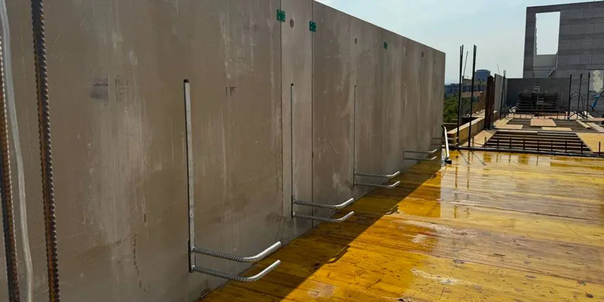 Ortbeton Attika am Flachdach mit unpräziser Geometrie und freiliegenden Bewehrungsanschlüssen – typischer Dachrand-Detailfehler