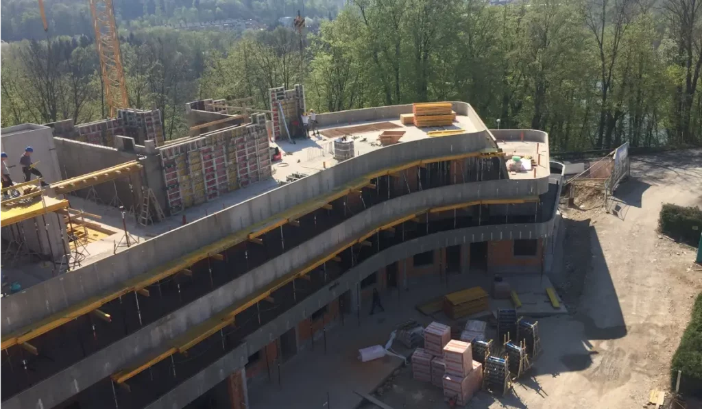  Fachgerechte Montage einer Attika Mauerabdeckung auf der Baustelle mit einem Kran.
